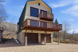 View of front of home featuring a balcony, an attached garage, and driveway