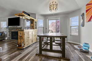 Dining area with a fireplace and dark wood-style floors