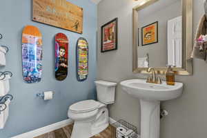 Half bath with toilet and wood finished floors