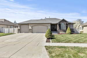 View of front of property with stone siding, a garage, and stucco siding