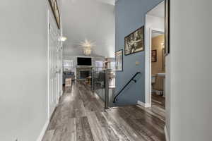 Hallway with an upstairs landing and dark wood-type flooring