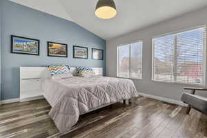 Bedroom with wood finished floors and vaulted ceiling