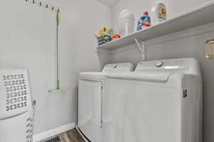 Laundry area with washing machine and clothes dryer and wood finished floors