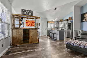 Living area featuring lofted ceiling and dark wood-style floors