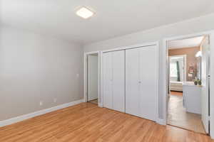 Unfurnished bedroom with light wood-style floors and a closet