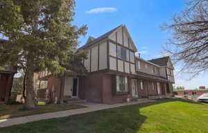View of front facade with brick siding and a front yard