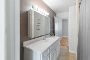 Bathroom with vanity, light tile patterned flooring, and a shower with shower curtain