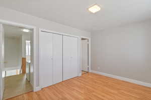 Unfurnished bedroom featuring light wood-style floors and a closet