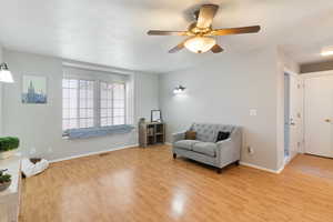 Living area featuring light wood-type flooring and ceiling fan