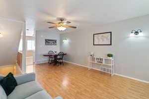 Living area featuring light wood-style floors and a ceiling fan