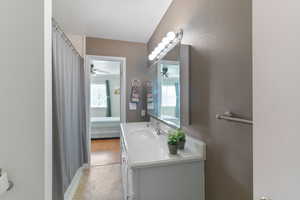 Full bathroom featuring vanity, healthy amount of natural light, connected bathroom, and curtained shower