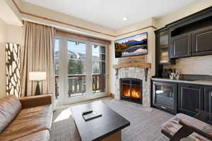 Living area with dark colored carpet and a fireplace