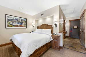Bedroom with baseboards and dark stone finish floors