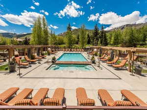 Community pool with a mountain view, a patio, and a hot tub