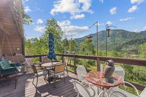 Wooden terrace featuring outdoor dining area and a mountain view