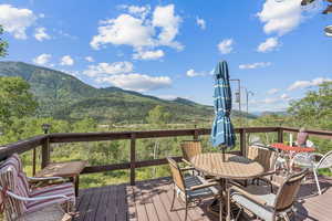 Wooden terrace with outdoor dining area and a mountain view