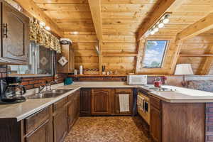 Kitchen featuring a peninsula, light countertops, white microwave, range with electric cooktop, and wooden ceiling