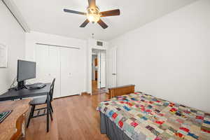 Second bedroom with light wood-style flooring, ceiling fan and closet