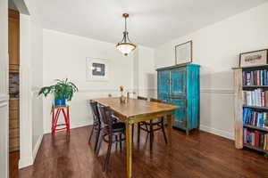 Dining room featuring dark wood-type flooring and chair molding