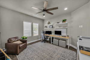 Home office with dark wood-style flooring, a ceiling fan, and recessed lighting