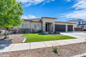 Prairie-style house with stone siding, a garage, stucco siding, and concrete driveway