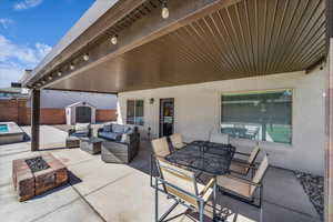 View of patio featuring a storage unit, an outdoor fire pit, and outdoor lounge area