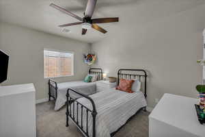 Carpeted bedroom with a ceiling fan and a textured ceiling