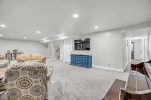 Living area featuring light colored carpet and recessed lighting
