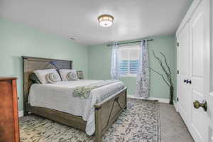 Bedroom featuring light carpet and a closet