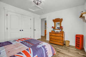 Bedroom with wood finished floors and a closet