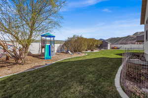 Playground with a fenced backyard and a mountain view