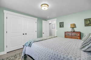 Carpeted bedroom with a closet and baseboards