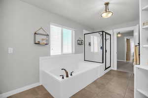 Primary Bathroom featuring a shower stall, a garden tub, and light tile patterned floors