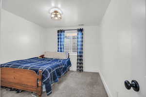 Bedroom with baseboards and light carpet