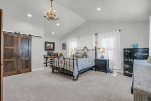 Carpeted primary bedroom with a barn door.