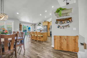Dining room with recessed lighting, vaulted ceiling, and dark wood-style floors