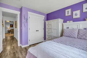 Bedroom with wood finished floors and a closet