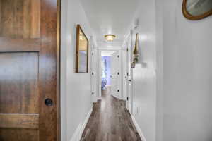 Corridor with baseboards and dark wood finished floors