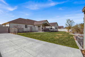 Back of property featuring a fenced backyard, a gate, a shingled roof, a patio, and stucco siding