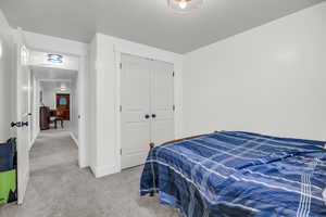 Carpeted bedroom with a closet and baseboards