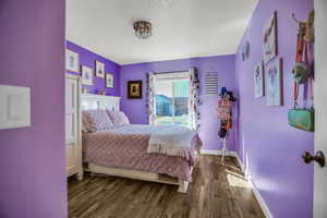 Bedroom with baseboards and dark wood finished floors