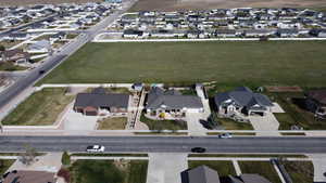 Aerial view of property and surrounding area featuring nearby suburban area