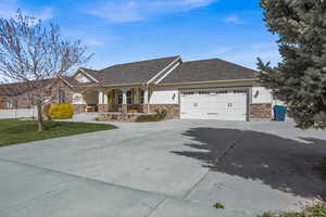 Craftsman house featuring covered porch, a garage, concrete driveway, stone siding, and stucco siding