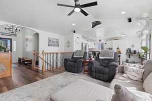 Living area featuring healthy amount of natural light, dark wood finished floors, arched walkways, and hanging lights