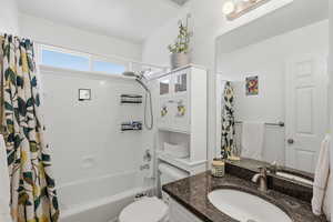 Full bathroom with shower / tub combo with curtain and vanity