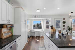 Kitchen with dark stone countertops, white cabinetry, dishwasher, dark wood finished floors, and recessed lighting