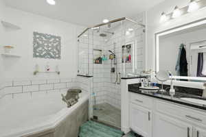 Full bathroom with vanity, a shower stall, and a bath