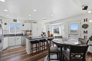 Dining space with dark wood finished floors, plenty of natural light, and recessed lighting
