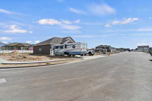 View of asphalt street featuring sidewalks, a residential view, and curbs