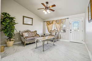 Sitting room featuring light marble finish floors, ceiling fan, and lofted ceiling